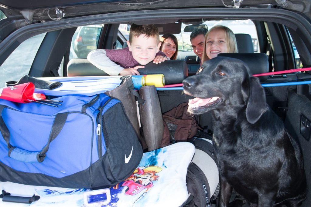 Family of four in fully-packed car ready for a holiday 