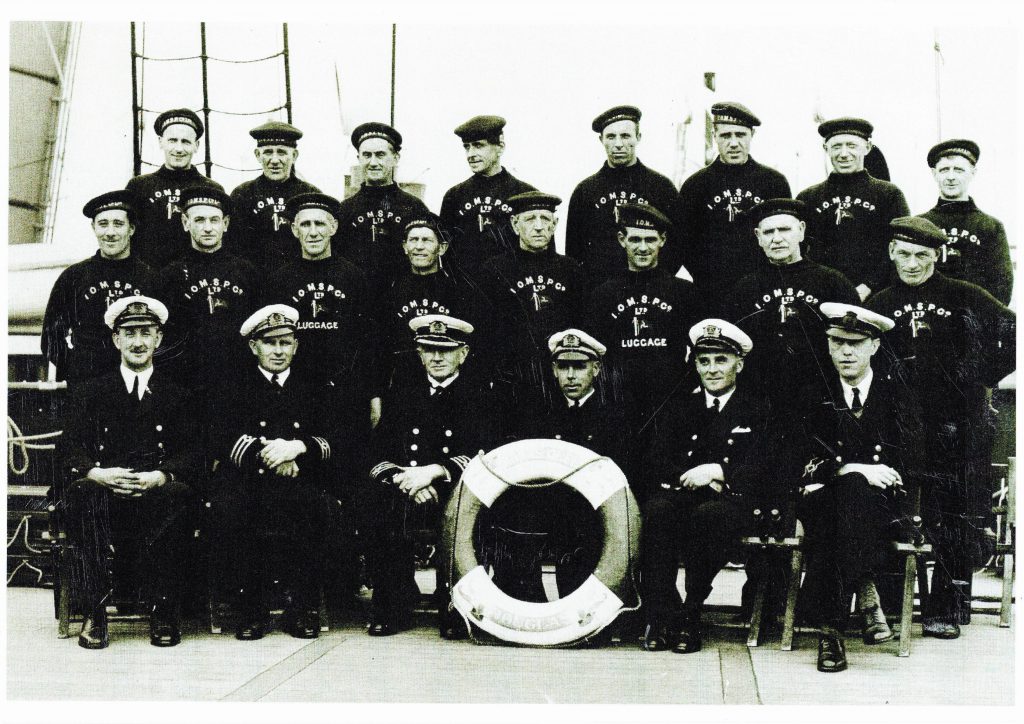 Black and white photo of Steam Packet Company crew on Mona's Queen posing on board the vessel 