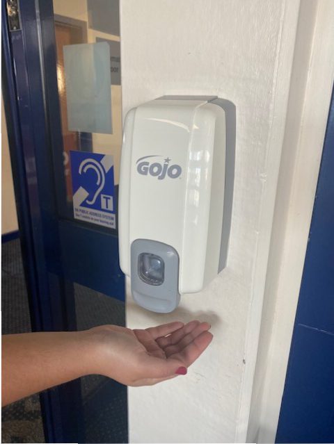 A photo of a hand sanitizing station at the Sea Terminal in Douglas with someone's hand underneath waiting for gel to come out 