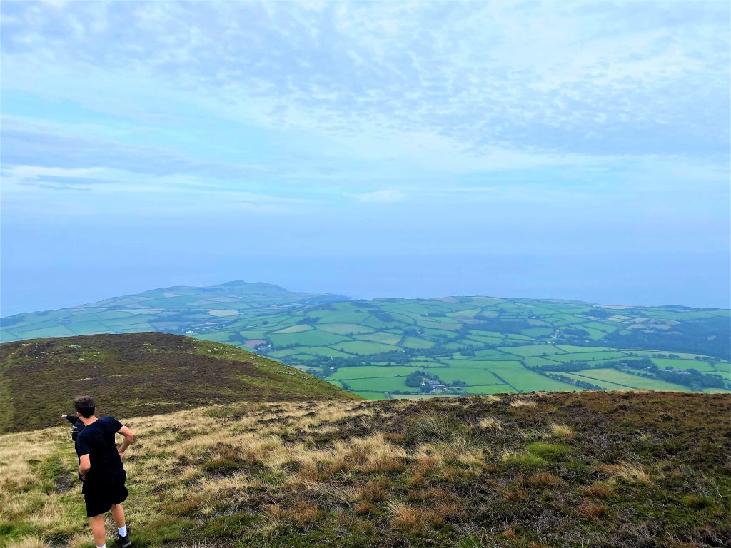 Views of the Isle of Man from the top of North Barulle with a man in the foreground