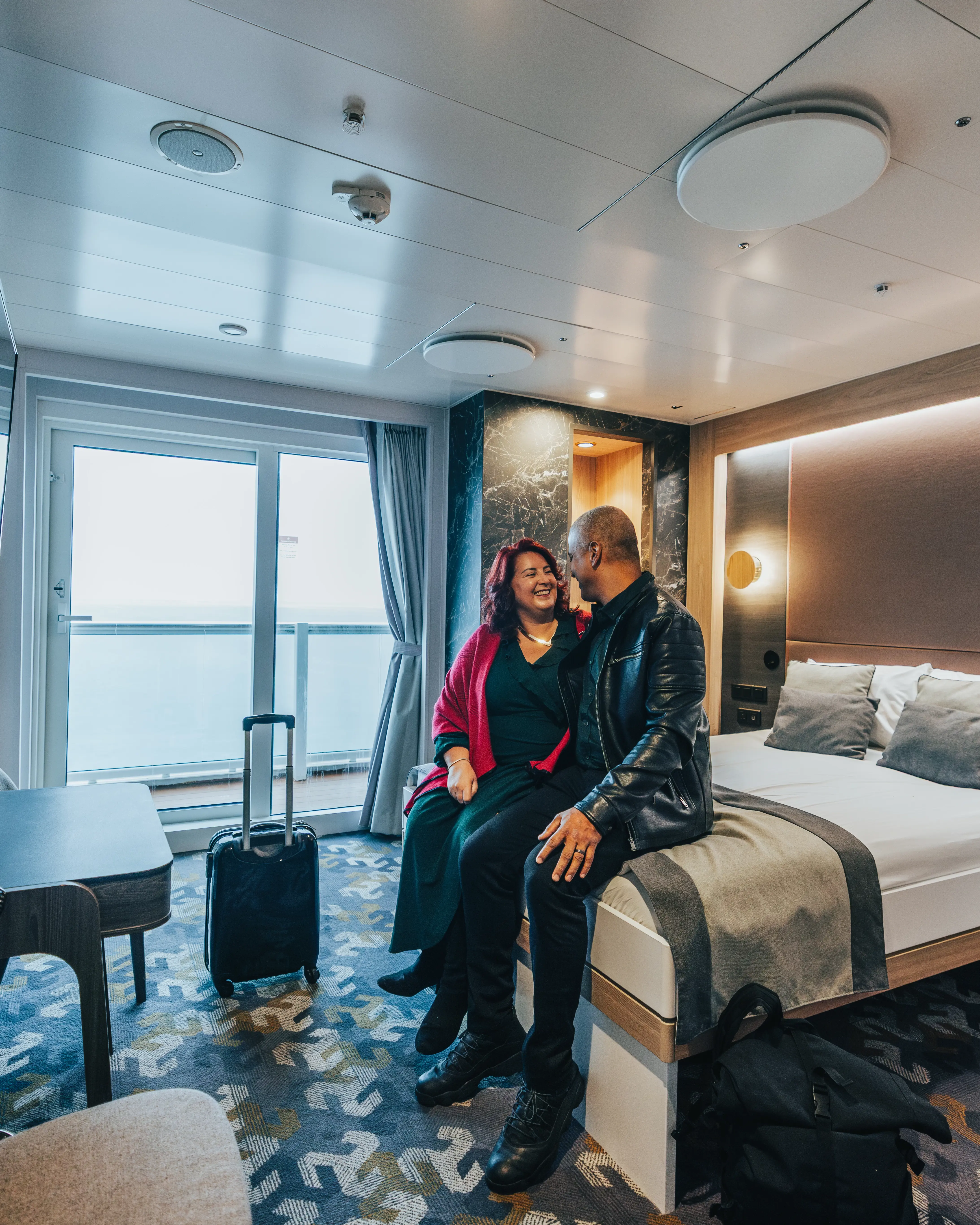 Two people sat on the bed in Manxman looking at each other