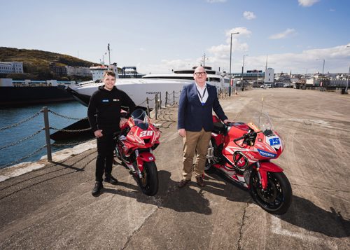 Two men (Nathan Harrison and Steam Packet Company MD Brian Thomson) at harbour standing beside motorcycles