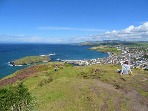 Someone sat down looking over Peel from Peel hill on a sunny day