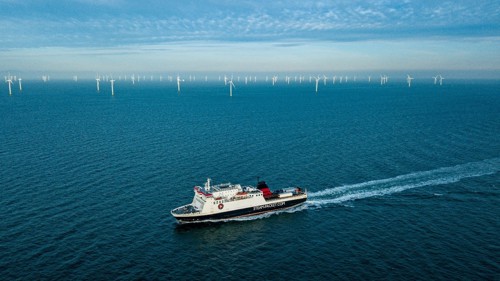 Ferry at sea with a large amount of sea wind turbines in the background