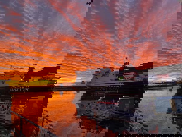 The Ben-my-Chree in Douglas Harbour in still waters against an orange sunrise