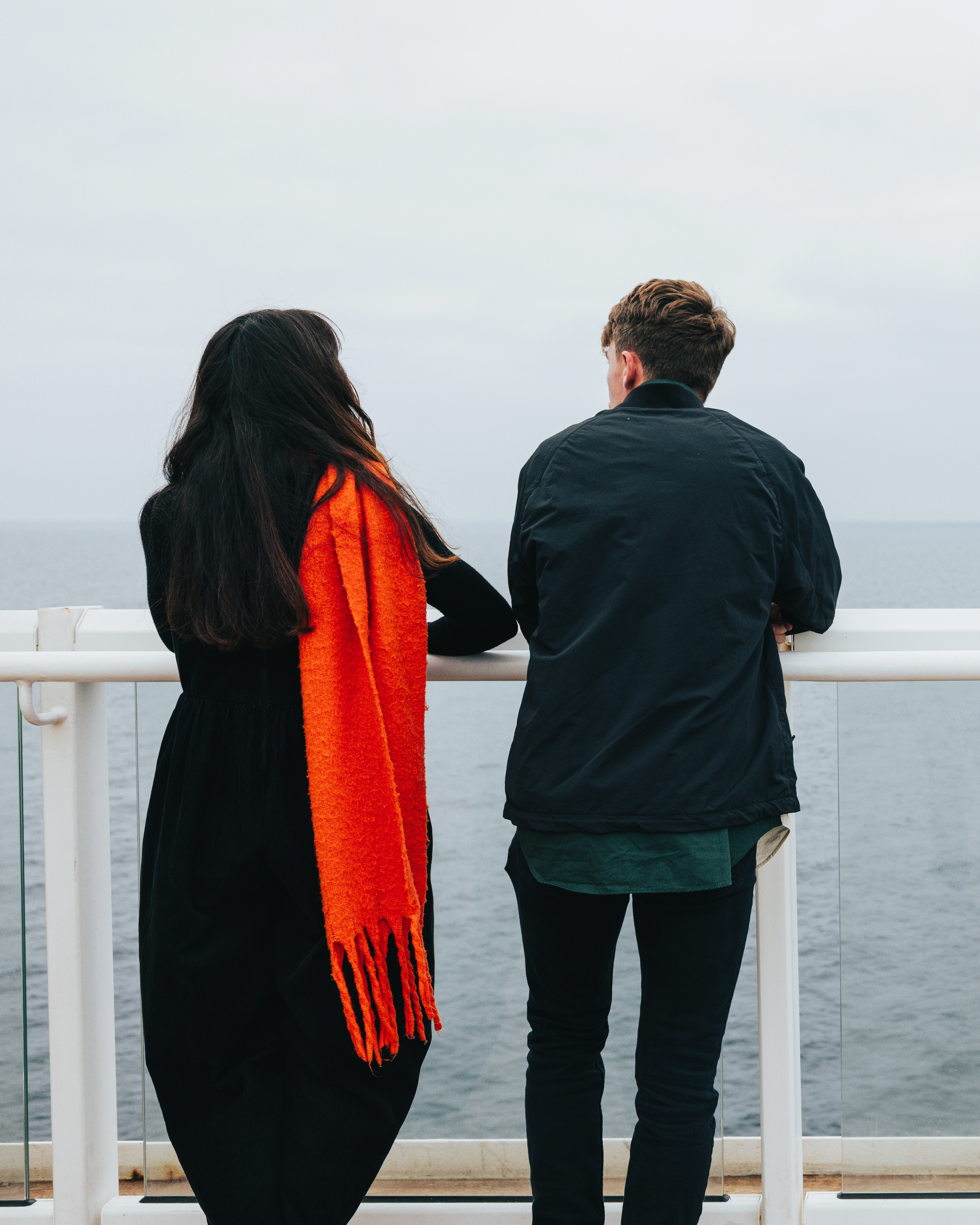 Two people overlooking the sea on the top deck of Manxman 
